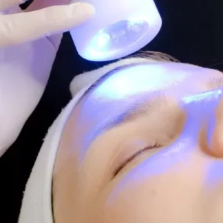 A person is getting their face illuminated by blue light.