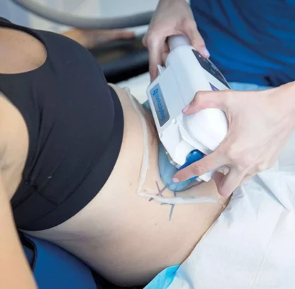 A person is using an ultrasound machine to treat her stomach.